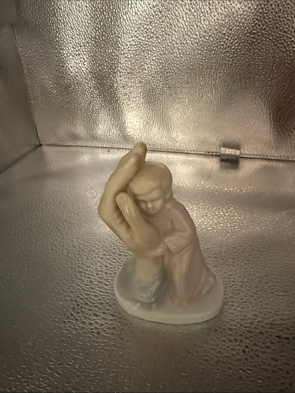 Vintage Porcelain small child cradled in a large palm.
